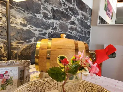 a vase with flowers on a table with a barrel at Boutique Chalet in Calheta in Arco da Calheta