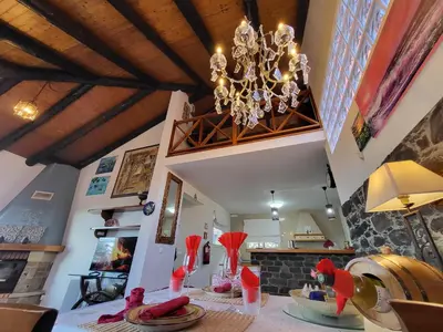 a dining room with a table with a chandelier at Boutique Chalet in Calheta in Arco da Calheta