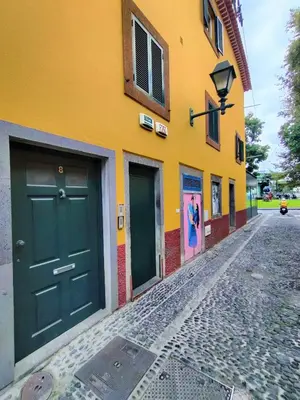 a yellow building with a green door on a street at Funchal Old Town Studios - Historic Atlantic View in Funchal