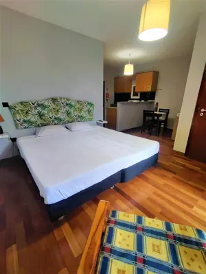 a bedroom with a large bed and a kitchen at Funchal Old Town Studios - Historic Atlantic View in Funchal