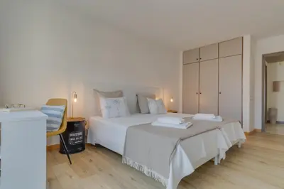 a bedroom with a large white bed and a dresser at avenida arriaga 405 in Funchal