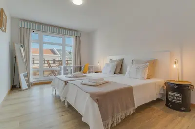 a bedroom with a large bed and a large window at avenida arriaga 405 in Funchal