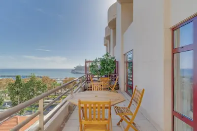 a balcony with a table and chairs and the ocean at avenida arriaga 405 in Funchal