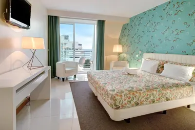 a hotel room with a bed and a desk and a television at Dfm Happy Days F - Funchal in Funchal
