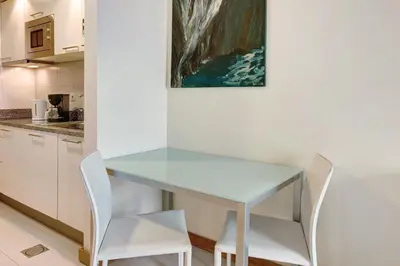 a table and chairs in a kitchen with a painting at Dfm Happy Days F - Funchal in Funchal
