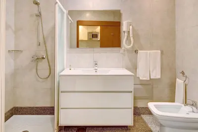 a bathroom with a sink and a toilet and a mirror at Dfm Happy Days F - Funchal in Funchal