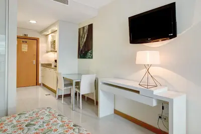 a bedroom with a desk and a tv on the wall at Dfm Happy Days F - Funchal in Funchal