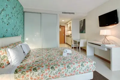 a bedroom with a bed and a desk and a television at Dfm Happy Days F - Funchal in Funchal