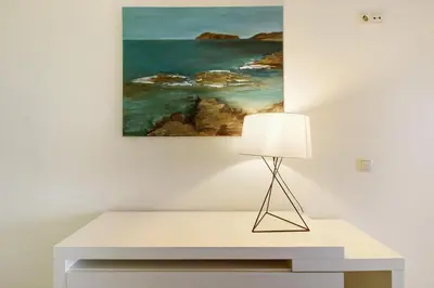 a table with a lamp and a painting on the wall at Dfm Happy Days C - Funchal in Funchal
