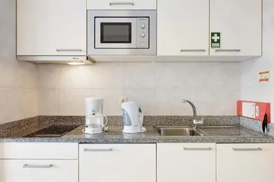 a kitchen with white cabinets and a sink and a microwave at Dfm Happy Days C - Funchal in Funchal