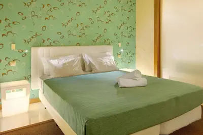a bedroom with a large bed with a green bedspread at Dfm Happy Days B - Funchal in Funchal