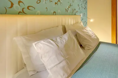 a bed with white pillows on top of it at Dfm Happy Days B - Funchal in Funchal