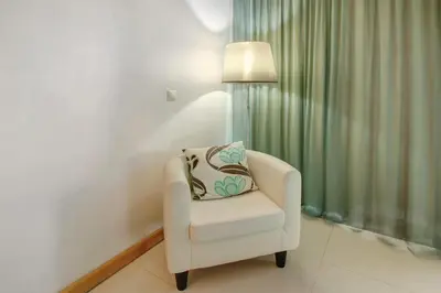 a white chair sitting in a room with a lamp at Dfm Happy Days D - Funchal in Funchal