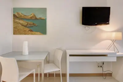 a dining room with a white table and a tv on a wall at Dfm Happy Days D - Funchal in Funchal