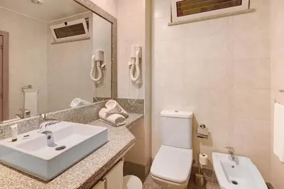 a bathroom with a sink and a toilet and a mirror at Dfm Happy Days D - Funchal in Funchal