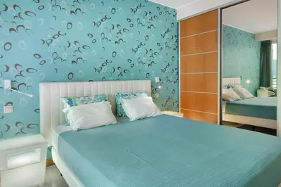 a bedroom with a blue bed and a mirror at Dfm Happy Days D - Funchal in Funchal