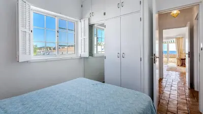 a bedroom with a bed and a view of the ocean at CoolHouses Algarve Luz, 3 Bed Townhouse, central & superb view, Casa Salute (100066/AL) in Luz