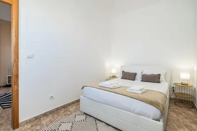 a bedroom with a large white bed with two lamps at Sunset House in Ribeira Brava