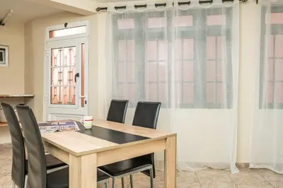 a dining room with a wooden table and chairs at Sunset House in Ribeira Brava