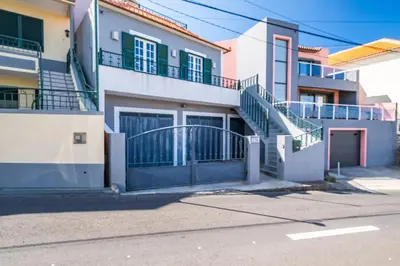 a apartment building with stairs and a gate at Sunset House in Ribeira Brava