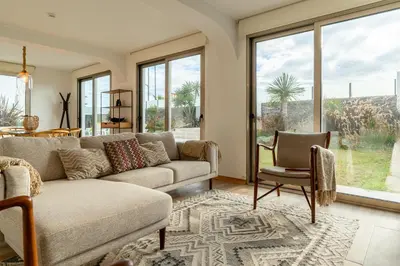 a living room with a couch and chairs and windows at Casa Paul do Mar in Paul do Mar