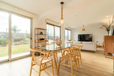 a dining room with a table and chairs and a living room at Casa Paul do Mar in Paul do Mar