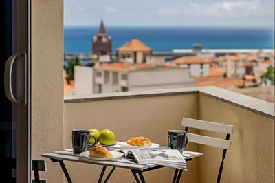 a table with bread and fruit on a balcony at Luxury in Funchal