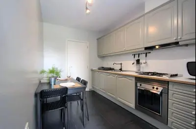 a kitchen with white cabinets and a table and chairs at Seashell II in Funchal