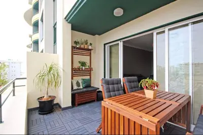a patio with a wooden table and chairs on a balcony at Seashell II in Funchal