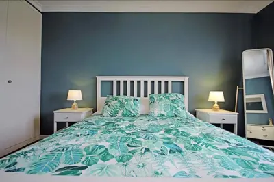 a bedroom with a large bed with blue walls at Seashell II in Funchal