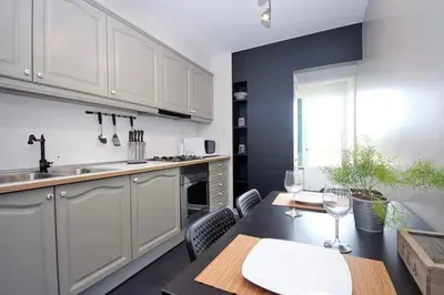 a kitchen with white cabinets and a table with wine glasses at Seashell II in Funchal