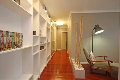 a hallway with white shelves and a chair and skis at Seashell II in Funchal