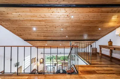 a staircase in a house with a wooden ceiling at Ivy Cottage by Homie in São Roque do Faial