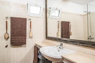 a bathroom with a sink and a mirror at Ivy Cottage by Homie in São Roque do Faial