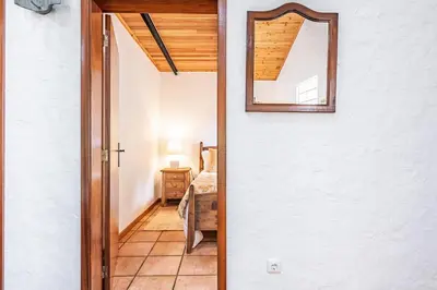 a door leading into a bedroom with a mirror at Ivy Cottage by Homie in São Roque do Faial