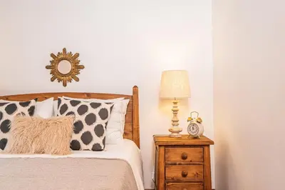 a bedroom with a bed and a lamp on a night stand at Ivy Cottage by Homie in São Roque do Faial
