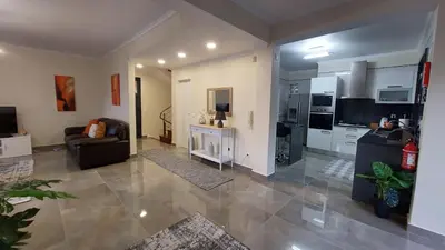 a large living room with a couch and a kitchen at Villa Strelitzia in Funchal