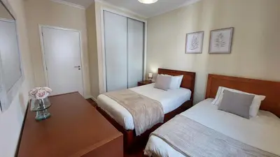 a hotel room with two beds and a table at Villa Strelitzia in Funchal