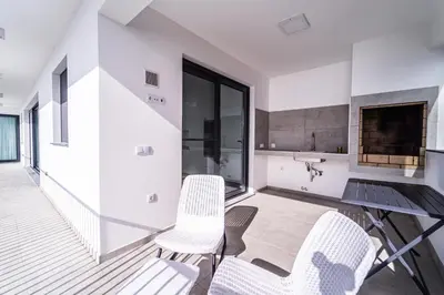 a kitchen and dining room with white chairs and a table at Guesthouse Olival in Santa Cruz
