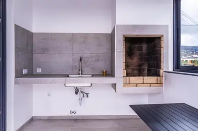 a kitchen with a sink and a fireplace at Guesthouse Olival in Santa Cruz