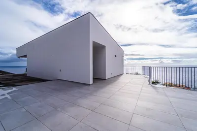 a white building on top of a balcony at Guesthouse Olival in Santa Cruz
