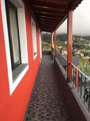 a corridor of a building with a red and white wall at Casa dos Avós Domingos & Matilde in Estreito da Calheta