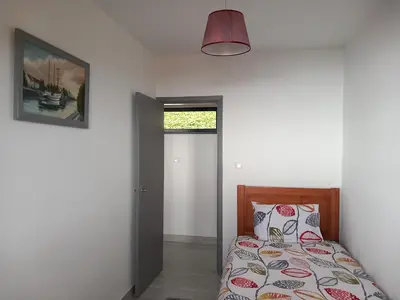 a bedroom with a bed and a picture on the wall at Casa dos Avós Domingos & Matilde in Estreito da Calheta