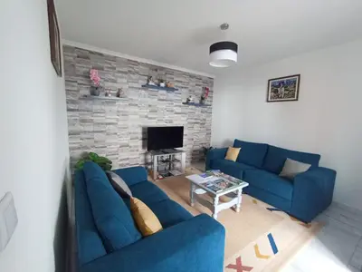 a living room with blue couches and a stone fireplace at Casa dos Avós Domingos & Matilde in Estreito da Calheta