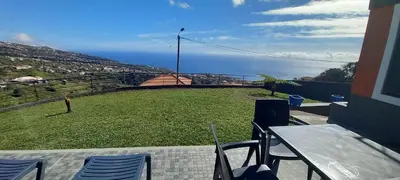 a balcony with a table and chairs and the ocean at Casa dos Avós Domingos & Matilde in Estreito da Calheta