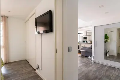 a living room with a flat screen tv on a wall at Lovely 1-bedroom apartment with parking ocean view in Funchal