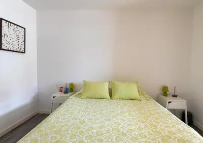 a white bedroom with a bed with two tables at Lovely 1-bedroom apartment with parking ocean view in Funchal