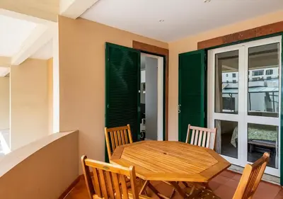 a dining room with a wooden table and chairs at Lovely 1-bedroom apartment with parking ocean view in Funchal