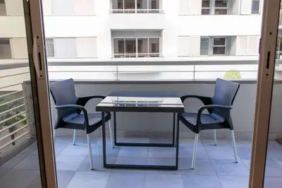 a table and benches in a building with palm trees at Elsas Place in Funchal