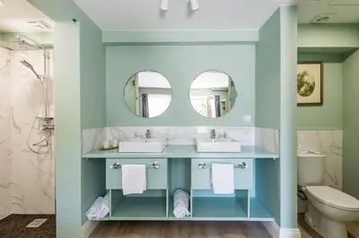 a bathroom with two sinks and two mirrors at Villa Camélia Boutique House in Camacha
